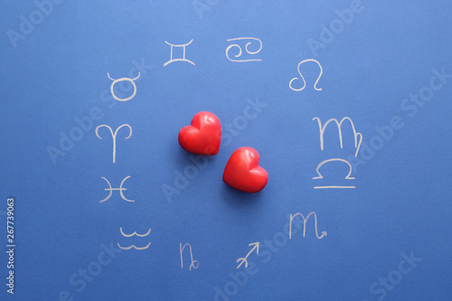 Zodiac signs and red hearts on color background. Love horoscope concept