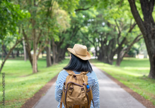 Happy young traveler woman backpacker travel in green natural forest ,greenery fresh air,Freedom wanderlust concept,Alone solo journey