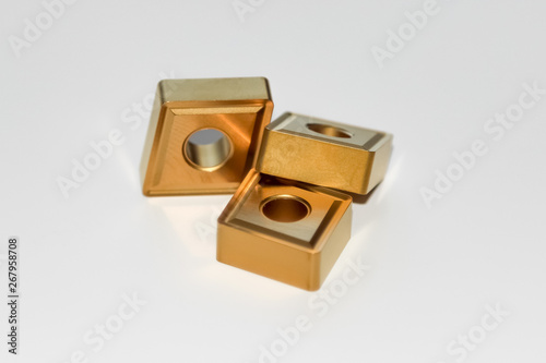 Three carbide inserts for CNC milling machine with selective focus isolated on white