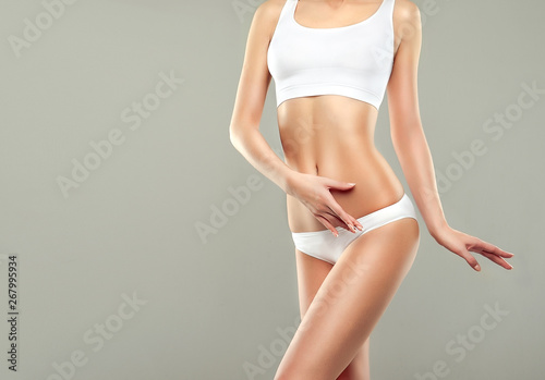  Perfect slim toned young body of the girl . An example of sports , fitness or plastic surgery and aesthetic cosmetology.