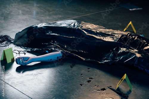 covered corpse with glasses on floor at crime scene