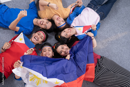 filipino group of people holding philippines flag celebrating independence day