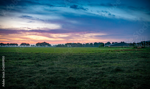Colorful sunrise, typical Dutch agricultural landscape