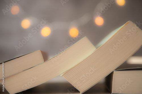 Leżące książki na szarym tle ze światełkami