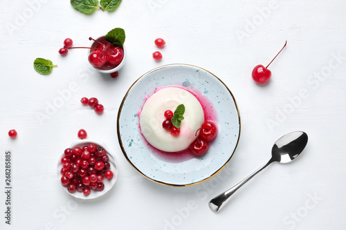 Plate with tasty panna cotta on white table