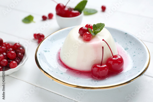 Plate with tasty panna cotta on white table