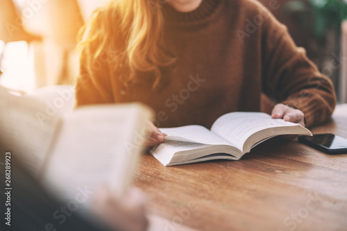 Group of people sitting and enjoyed reading books together on wooden table