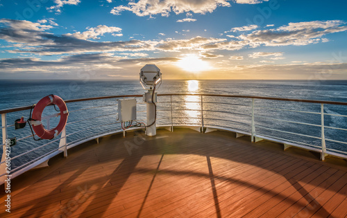 Wooden deck and railing from cruise ship. Beautiful sunset and ocean view.