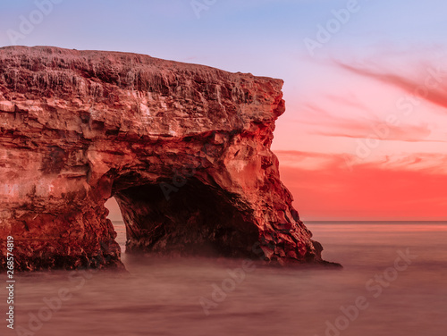 Incredible natural arch in the huge rock at sunset