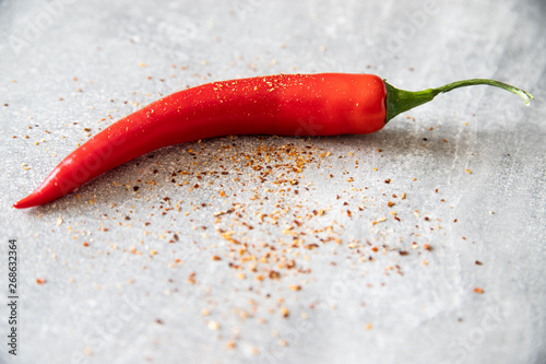 Czerwona papryczka chilli i rozsypana przyprawa 