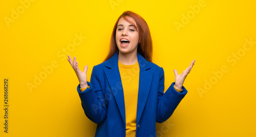 Young redhead woman with trench coat smiling a lot