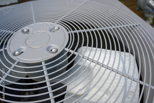 Residential air conditioning unit outdoors with fan and coils