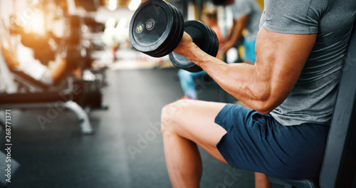 Determined handsome and young male working out in gym