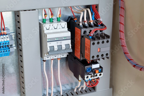 Circuit breaker, contactor or starter with additional contacts and thermal relay in electrical Cabinet. Electric control Cabinet for pumps or motors. The wires are connected to electrical equipment.