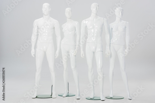 white plastic mannequins in row on grey