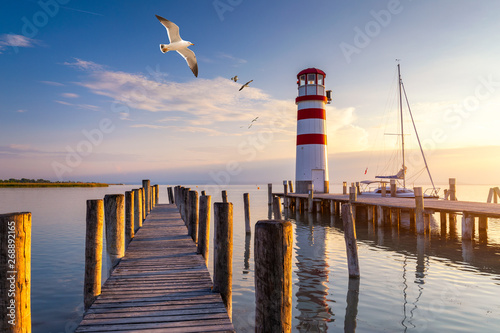 Lighthouse at Lake Neusiedl at sunset near Podersdorf with sea gulls flying around the lighthouse. Burgenland, Austria