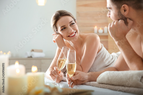 Romantic young couple with champagne in spa salon