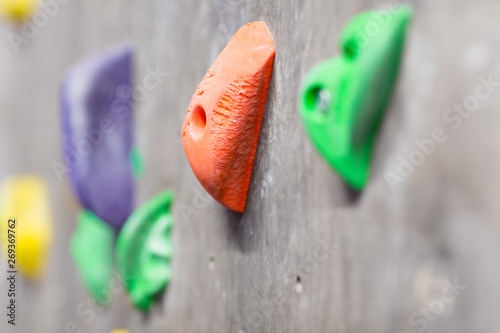 fitness, extreme sport, bouldering, people and healthy lifestyle concept - close up of rock holder on indoor climbing wall
