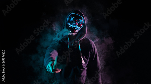 Chico con mascara de luces sobre un fondo negro con humo