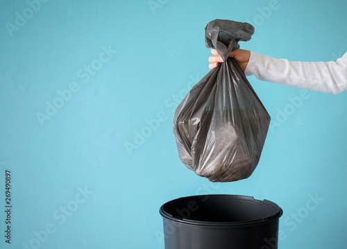 Hand holding garbage in plastic bag