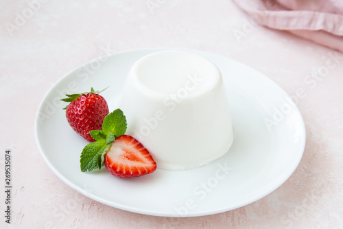 Panna cotta, traditional italian dessert, served with fresh strawberry and mint