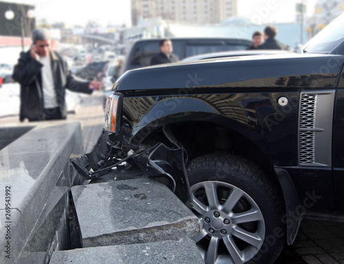 Car crash accident. Luxury car crashed into a stone fence.