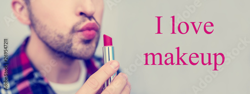 White metrosexual, man holding red lipstick in his hand close to face, on camera, lettering, I love makeup, front view, close up,