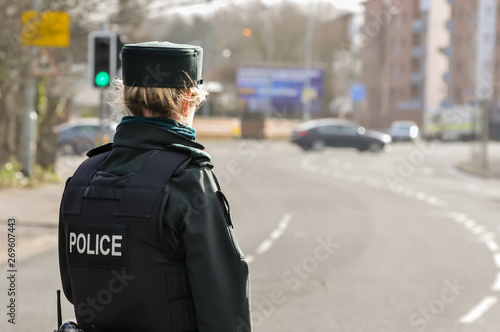 A police woman stands guard at a road in Belfast, while army ATOs defuse a bomb which was left in a residential area.