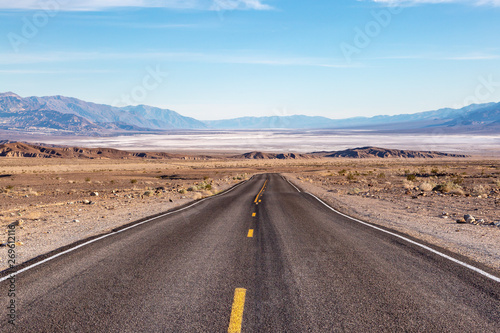 Looking down a road leading into Death Valley in California, with salt flats and a vast landscape ahead