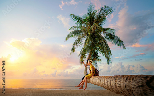 Asian couple selfie by camera on coconut palm tree in Kho Mak island