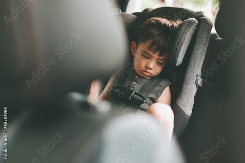 A boy sleeping in the car