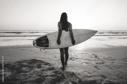 Nostalgia and remembrance photo of surfer woman in bikini go to surfing. beautiful sexy woman with surfboard on beach. black and white color tone.