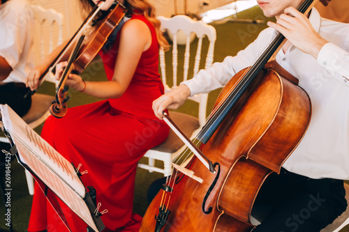 The music quartet plays at the wedding. String Quartet. The actor performs at a party. musical instrument.