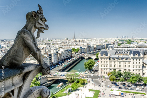 Notre-Dame de Paris. Famous Chimera demon overlooking the Eiffel Tower from Cathedral Notre Dame in Paris, France.