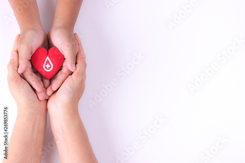 Woman and child hands holding red heart for blood donation concept,World blood donor day, health care love, hope and family concept, world heart day,world health day. Copy space for advertisers.