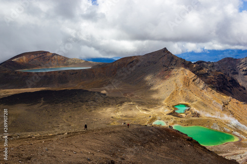 Landscape view of colorful Emerald lakes and volcanic landscape with hikers walking by, Tongariro national park, New Zealand