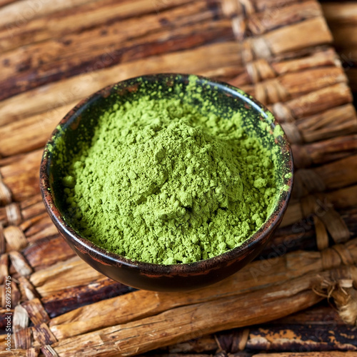 Powdered matcha green tea on bamboo background