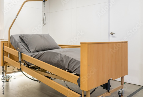 Electrical adjustable patient bed in hospital room. Technology of medical and hospital services.