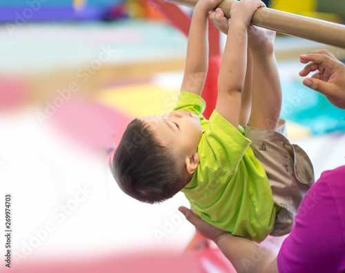 Little toddler boy working out at the indoor gym excercise