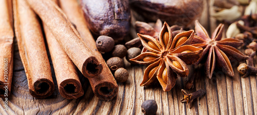 Christmas winter spices and blue pine tree branch on wooden background. Close up.