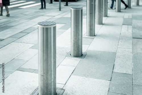 Stainless steel bollard entering pedestrian area on Vienna city street. Car and vehicle traffic access control