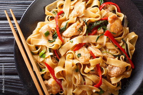 pad kee mao rice noodles with chicken, basil, chili pepper and sauce close-up on a plate. horizontal top view