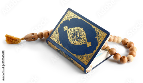 Muslim beads and Koran on white background