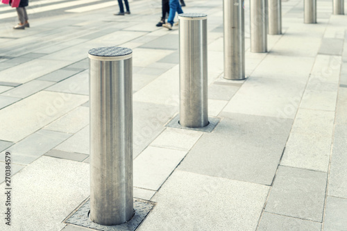 Stainless steel bollard entering pedestrian area on Vienna city street. Car and vehicle traffic access control