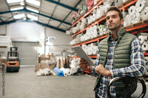 Warehouse worker checking stock using a digital tablet