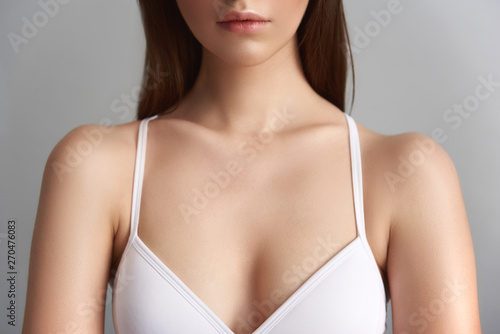 Beautiful lady in bra isolated on grey background