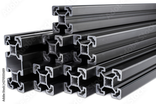 stack of black anodized aluminum extrusion bars, isolated white background. Construction metal steel factory concept.