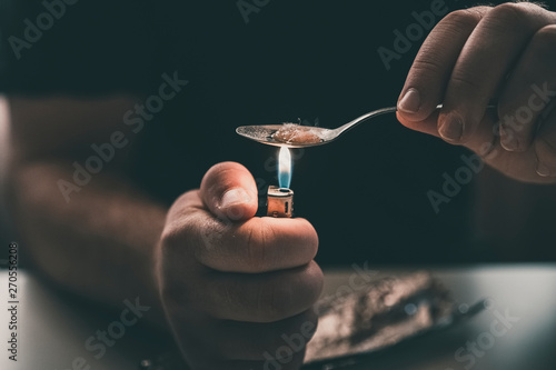 Addict at the table with a syringe heroin methamphetamine addiction