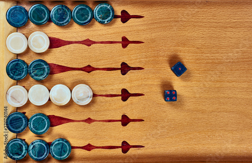 Backgammon game. Game dice made of stone lie on the backgammon board against the background of checkers. Flat lay