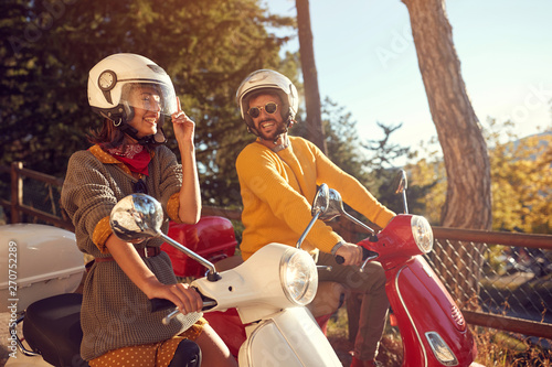 Cheerful man and woman riding a scooter and having fun..